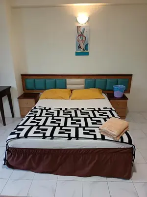 a bedroom with a bed with a black and white comforter at Lumut Valley in Lumut