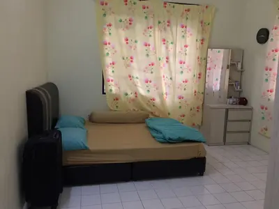 a small bed in a room with a curtain at Taiping Desa Jana Home Stay in Kamunting