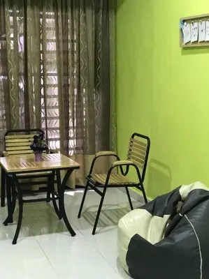a room with a table and two chairs and a window at Kinaz homestay in Ipoh