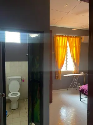 a bathroom with a toilet and a window at Aqil Homestay Lunas Kulim for Mslim only in Lunas