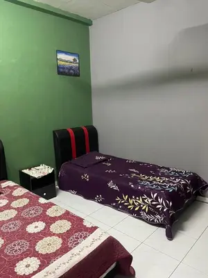 a bedroom with a bed and a bedspread on it at Aqil Homestay Lunas Kulim for Mslim only in Lunas