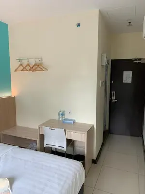 a bedroom with a desk and a bed and a bed and a table and chair at M Quality Hotel in Gua Musang