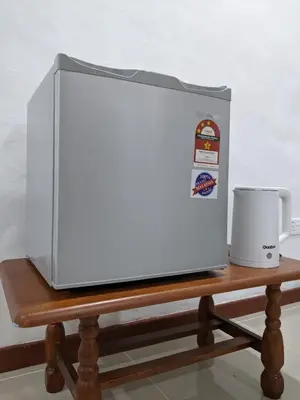 a microwave oven sitting on a table with a coffee mug at Denai Senja in Kuala Selangor