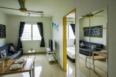 a living room with a couch and a television at Palm Court in Tanjong Tokong