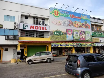 two cars parked in front of a building at LA MOTEL in Sungai Petani
