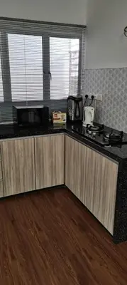 a kitchen with wooden cabinets and a counter top at Citra Cottage Homestay in Sungai Petani
