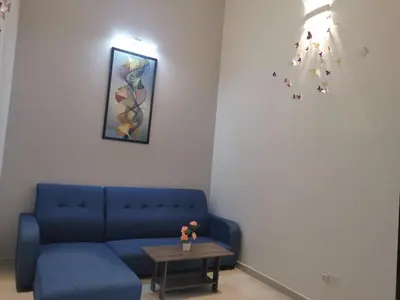 a living room with a blue couch and a table at 48 \u60a0\u4e4b\u5904NO . 48, PERSIARAN ALAM IMPIAN 3 VILLA RIADAH ALAM IMPIAN PANGKOR, 32300 PANGKOR , PERAK. in Pangkor