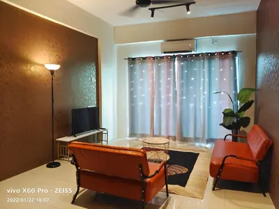 a living room with a chair and a table and a window at PavilionVillie Ipoh in Kampong Sengat