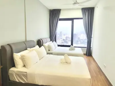 two beds in a room with a large window at Tropicana 218 Macalister Water Purifier By Blue Sky Holidays in George Town