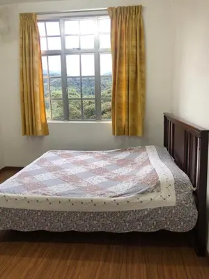a bedroom with a bed in front of a window at BRINCHANG CENTRE 3 ROOMS APARTMENT in Cameron Highlands