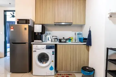 a kitchen with a refrigerator and a washing machine at Tropicana 218 Macalister at Georgetown 2Carparks in George Town