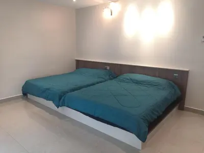a bedroom with two beds with green comforters at Orkid Apartment in Cameron Highlands