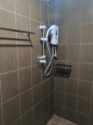 a shower with a hair dryer in a bathroom at Orkid Apartment in Cameron Highlands