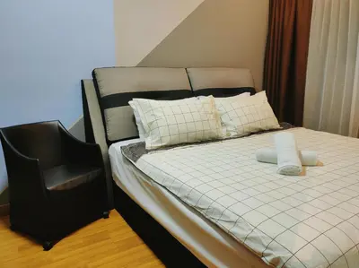 a bed with two pillows and a chair in a room at Dual Key 3BR at Macalister 218 Georgetown 32 WL in George Town