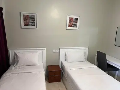 two beds sitting next to each other in a room at Jarzmin Double Story Homestay @ Royal Lily in Tanah Rata