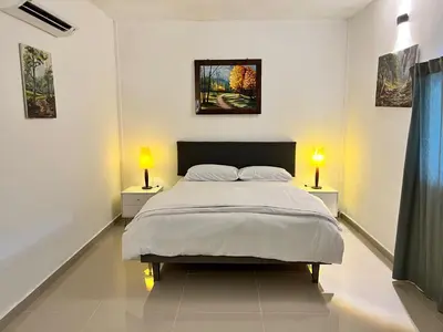 a white bedroom with a bed and two lamps at Bertam Cottage Penang in Kepala Batas