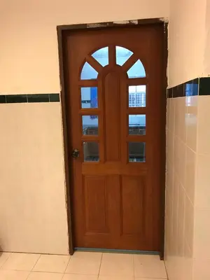 a wooden door with a window in a room at Suria Permai Homestay in Taiping