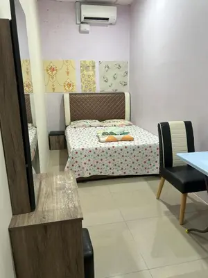 a small bedroom with a bed and a chair at Cyber Loft Homestay in Ipoh