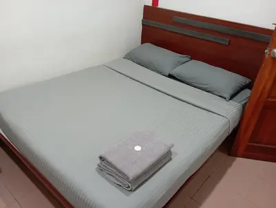 a bed with two towels sitting on top of it at Evonne Budget Hotel in Tanah Rata