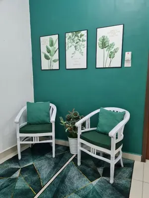 two chairs in a room with blue walls at Embon Homestay in Padang Serai