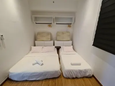two beds in a small room with white walls at Beacon Executive Suites in George Town