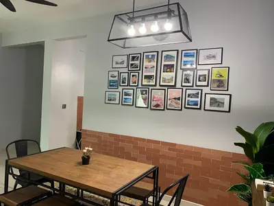 a dining room with a table and pictures on the wall at Ammar SkyHome Ipoh in Ipoh