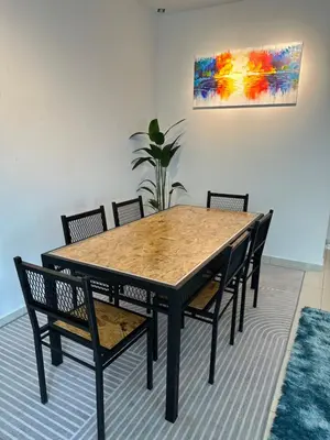 a dining room table with chairs and a painting on the wall at Adelea Homestay MERU in Ipoh