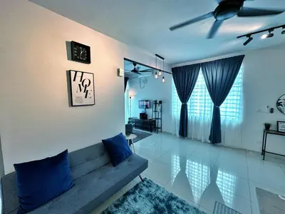 a living room with a couch and blue pillows at Adelea Homestay MERU in Ipoh