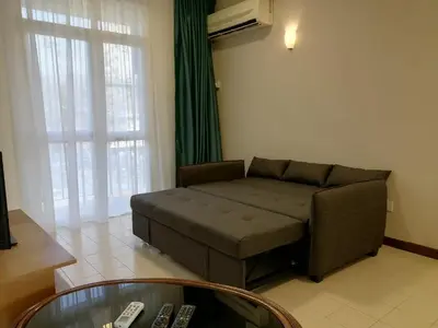 a living room with a couch and a coffee table at Bayu Emas Apartment by Wellington Resorts in Batu Ferringhi