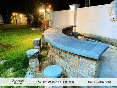 a brick fire pit in a backyard at night at Prairie Villa Homestay in Lumut