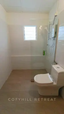 a bathroom with a toilet and a shower at CofyHill Retreat in Kampong Changkat Tualang