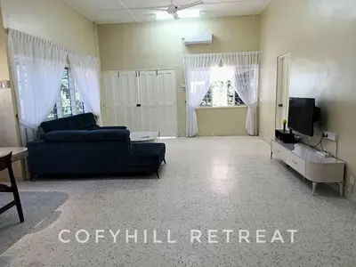 a living room with a couch and a tv at CofyHill Retreat in Kampong Changkat Tualang