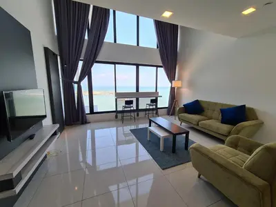 a living room with a couch and a tv and a table at Sunrise Gurney Executive Premium Suite in George Town
