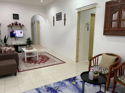 a living room with a couch and a table at Rose Homestay in Sitiawan