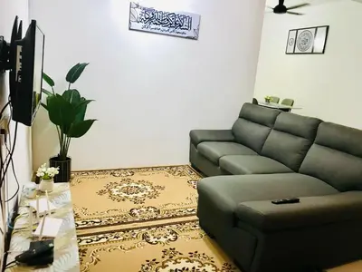 a living room with a couch and a table at Chempaka Homestay (Near to UTP UiTM Seri Iskandar) in Seri Iskandar
