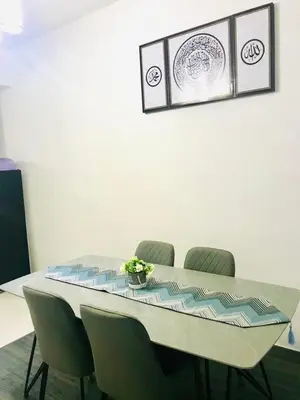 a dining room table with four chairs around it at Chempaka Homestay (Near to UTP UiTM Seri Iskandar) in Seri Iskandar