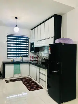 a kitchen with a black refrigerator and white cabinets at Chempaka Homestay (Near to UTP UiTM Seri Iskandar) in Seri Iskandar