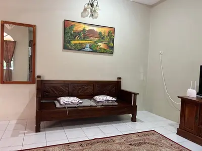 a wooden bench in a room with a mirror at To' Teh Homestay in Ipoh