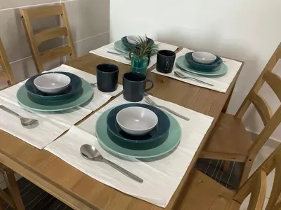 a wooden table with plates and utensils on it at SCANDI HOMESTAY IPOH muslem in Ipoh