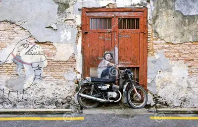 a motorcycle parked in front of a building with a painting at Central Georgetown - Loft House in George Town