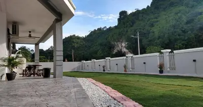 a house with a white fence and a grass yard at LOW SEASON PROMOTION! Mountainview Corner Lot 10 pax in Ipoh