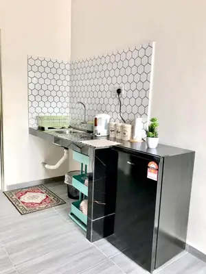 a kitchen with a black counter with a sink at Teratak Ar-Rayyan x Villa Abi in Batu Kurau