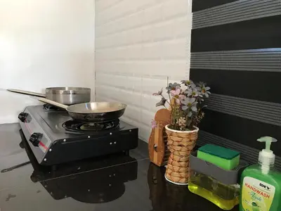 a kitchen with a stove with a pot on it at Teratak Ar-Rayyan x Villa Abi in Batu Kurau