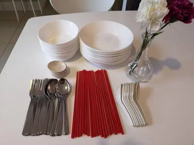 a table with forks and plates and a vase with flowers at W3WarmStay@GoldenHills/3RPenthouse/WiFi/PasarMalam/2carpark in Brinchang