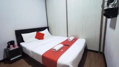 a bedroom with a bed with a red and white blanket at Hotel Rasa Sayang 2 in Tanah Rata