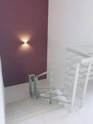 a staircase with a light on a purple wall at W6WarmStay@GoldenHills/3RPenthouse/WiFi/PasarMalamView/2carpark in Brinchang