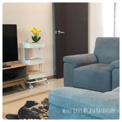 a living room with a blue chair and a television at Meru Oasis at Casa Kayangan Ipoh in Ipoh
