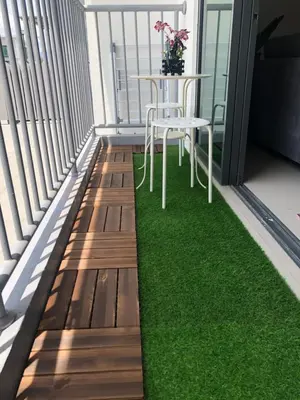 a table and chair on a balcony with green grass at Meru Oasis at Casa Kayangan Ipoh in Ipoh
