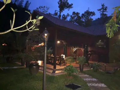 a house with a patio at night at Kemuning Orchard Villaa in Kerling