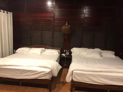 two beds with white sheets in a room at Kemuning Orchard Villaa in Kerling